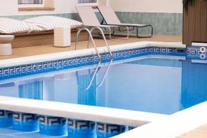 a swimming pool with a chair and a chaise lounge at RVHotels Mar de Tossa in Tossa de Mar