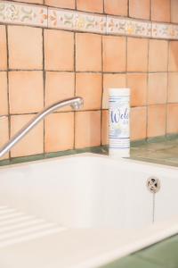 a can of medicine sitting on a counter next to a sink at Domina House by ElbaSummer in Marciana +26 photos