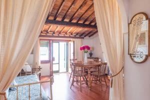 a dining room with a table and chairs and a room at Domina House by ElbaSummer in Marciana
