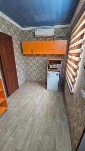 a small kitchen with a stove and a refrigerator at Гостиница Саян in Shymkent