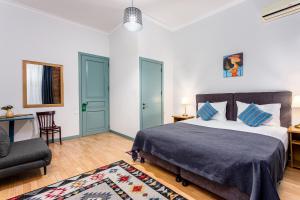 a bedroom with a bed and a chair and a couch at Ethno Sololaki in Tbilisi City