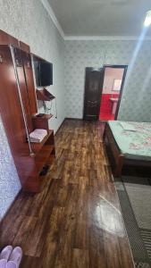 a room with a bedroom with a bed and a desk at Гостиница Саян in Shymkent +1 photo