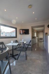 a dining room with tables and chairs and a tv at PRIMA FILA Premium Guest House in Sanremo