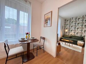 a living room with a table and a couch at Le Tinqueux Chic-Studio rénové proche centre reims in Reims