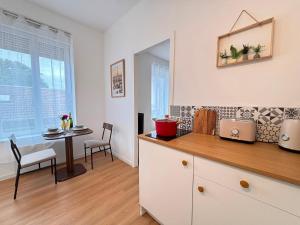 a kitchen with a table and a dining room at Le Tinqueux Chic-Studio rénové proche centre reims in Reims +20 photos
