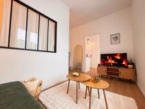 a living room with a couch and a fireplace at Le Tinqueux Chic-Studio rénové proche centre reims in Reims