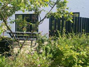 a garden with a bench in front of a house at Pura Vita in Horebeke
