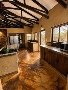 a large kitchen with wooden floors and a ceiling at Wonderviews Hedgehog in Marloth Park