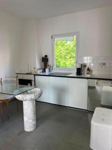 a kitchen with a sink and a table and a window at Arazzo Apartments in Modena