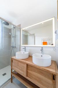 a bathroom with two sinks and a mirror at Hôtel La Chaumière-Les Pastourelles in Capbreton +10 photos