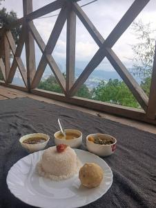 a table with a plate of food and bowls of soup at Katus in Gangtok