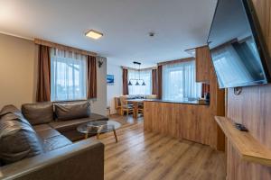 a living room with a couch and a table at Maiskogelblick Apartments by we rent in Piesendorf