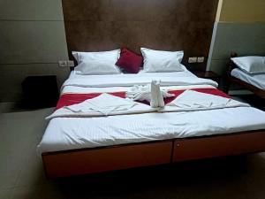 a bedroom with two beds with towels on them at Hotel Royal Park in Mangalore