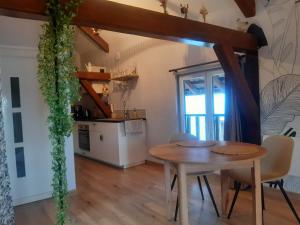 a dining room with a table and a kitchen at Gîte de l'Ancienne Forge in Epfig +21 photos