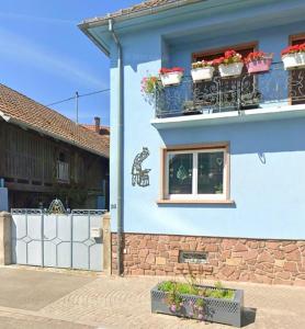 a blue building with flower boxes on the windows at Gîte de l'Ancienne Forge in Epfig