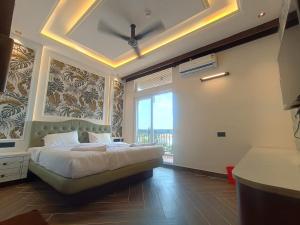 a bedroom with a bed and a large window at Hotel J VIN PALACE in Mysore