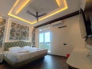 a bedroom with a large bed and a large window at Hotel J VIN PALACE in Mysore