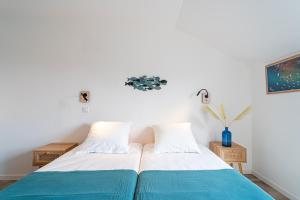a bedroom with two beds with blue and white sheets at Hôtel La Chaumière-Les Pastourelles in Capbreton