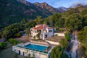 an aerial view of a house with a swimming pool and mountains at Villa Excelsior in Porto Ota
