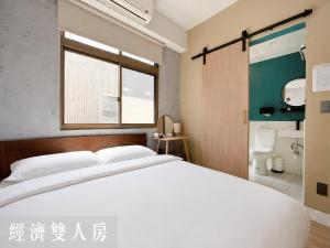 a bedroom with a large white bed and a bathroom at Littlesay in Tainan +27 photos