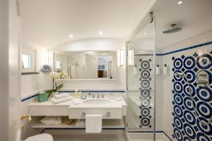 a white bathroom with a sink and a shower at Hotel Buca Di Bacco in Positano +169 photos