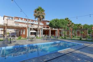 a swimming pool in front of a house at Dolanit Hotels Lalez in Draç