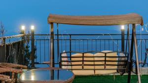 a chair and a glass table on a balcony at Yeosu Bokja Spa Pension in Yeosu