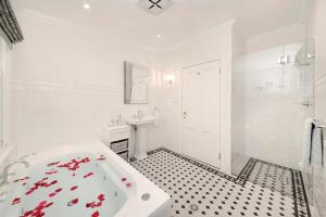a white bathroom with a tub and a sink at Poets Cottage c1912 Scenic Hikes, Fire, Spa Bath in Wentworth Falls +17 photos