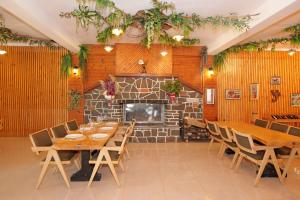 a dining room with wooden tables and chairs and a fireplace at Dolanit Hotels Lalez in Draç