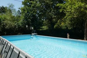 a swimming pool with a chair in the water at Ondas Eco-Gîtes in Arsagne