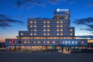 a large building with a sign on top of it at Manxin Hotel Nanjing Mufu Mountain in Nanjing