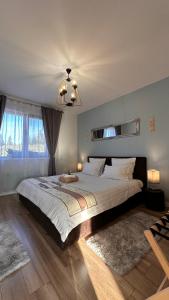a bedroom with a large bed and a chandelier at Cozy Living in Dealu Negru