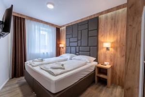 a bedroom with a large bed with a wooden wall at Maiskogelblick Apartments by we rent in Piesendorf