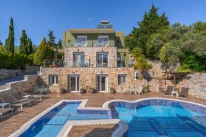 a villa with a swimming pool in front of a house at Kalokairi Boutique Residence in Skopelos Town