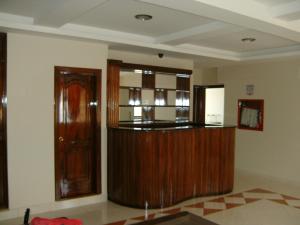 a living room with wooden furniture and a door at Hostal Fevilamir in Ibarra