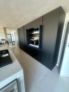 a kitchen with a black wall with an oven at Sunset Villa Herolds Bay in Herolds Bay