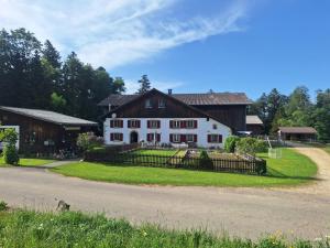 a large white house with a fence and a road at L'appart Les Fontaines in Tramelan