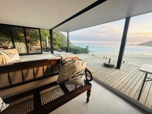 a house with a balcony with a view of the ocean at Sunset Villa Herolds Bay in Herolds Bay