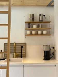 a kitchen with a sink and a coffee maker at Lüttje Huus Emden- Tiny House zentral am Hafen & Otto Huus in Emden