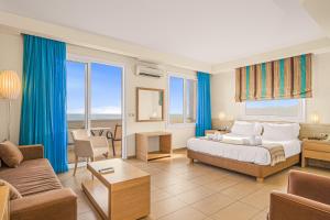 ein Hotelzimmer mit einem Bett und einer Couch in der Unterkunft Glaros Beach Hotel in Hersonissos