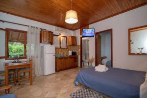 a bedroom with a bed and a kitchen with a refrigerator at Kastraki Villas in Nafplio