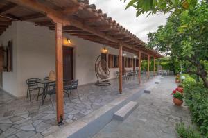 a patio with a table and chairs under a pergola at Kastraki Villas in Nafplio