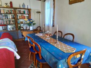 a dining room with a blue table and chairs at L'ora d'aria in Bardi +8 photos