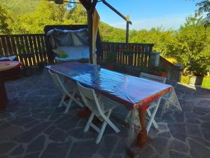 a picnic table on a patio with an umbrella at L'ora d'aria in Bardi
