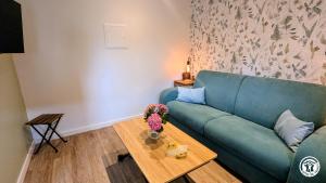 a living room with a blue couch and a table at Le Tandem in Losne
