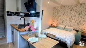 a small room with a bed and a table with flowers at Le Tandem in Losne
