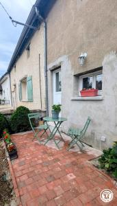 a patio with a table and a bench in front of a building at Le Tandem in Losne