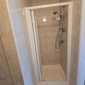 a shower with a glass door in a bathroom at 18 Clifden Court in Clifden +13 photos