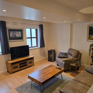 a living room with a couch and a tv at 18 Clifden Court in Clifden