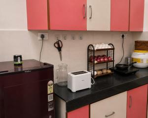 a kitchen with red cabinets and a counter with a toaster at 2 BHK full apartment in Mohali